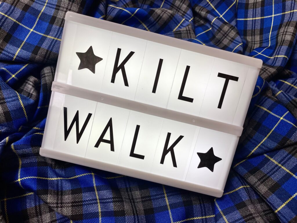 Lightbox that has a star on it and says kiltwalk, spread over two lines. The box is sitting on a blue tartan.