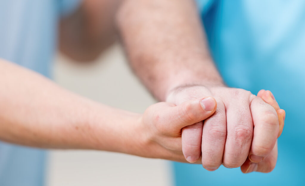 one person's hand holding another hand to show support.