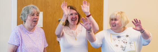 Three woman singing and dancing